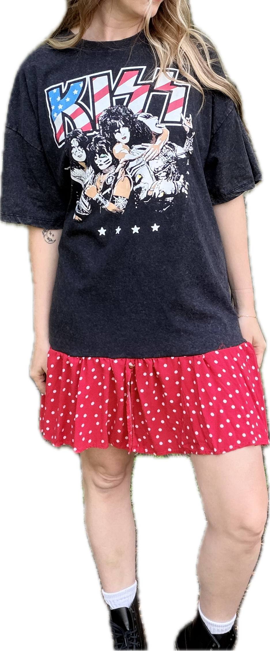 Person wearing a black 'KISS' t-shirt and red polka dot skirt on a white background